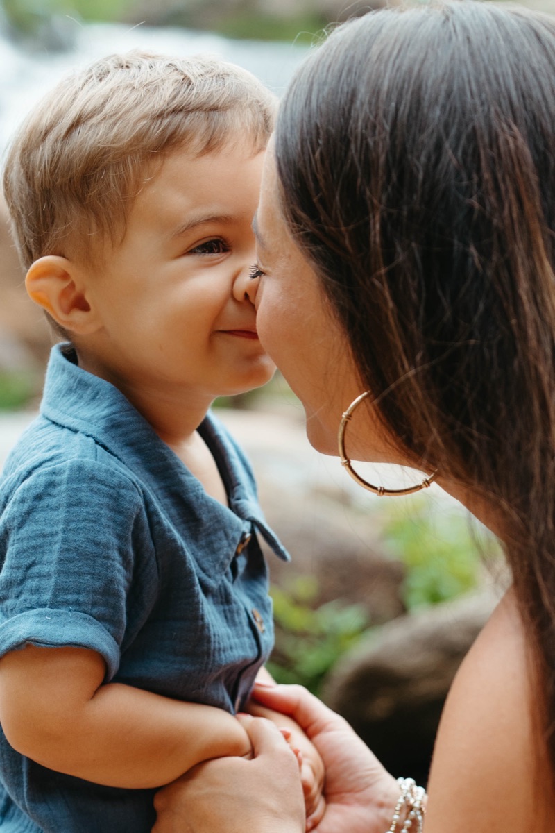 Mother and son touching noses by the river