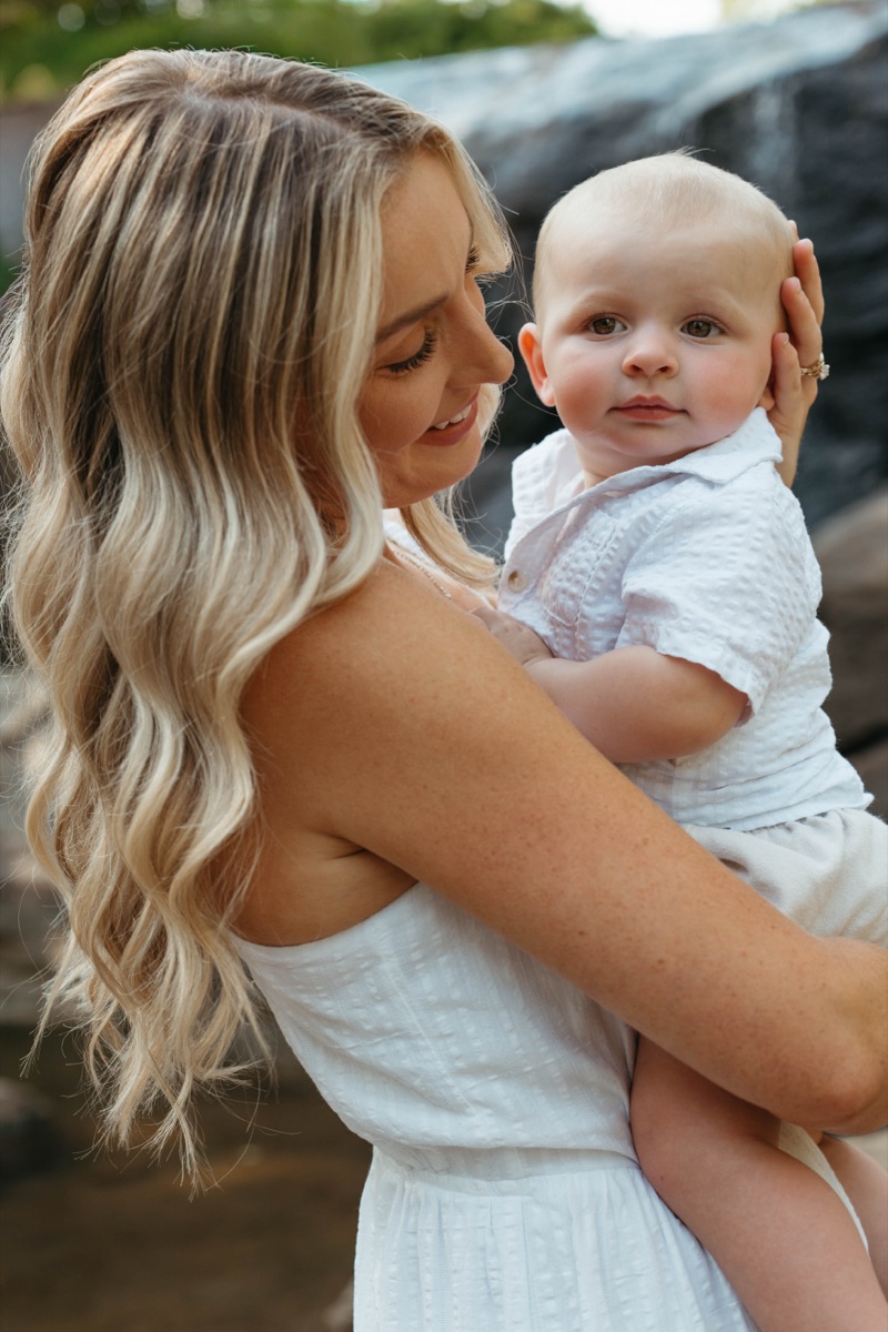 Mother holding her baby by the water