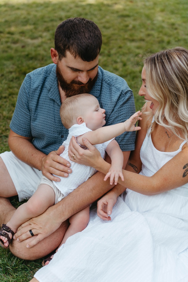 Parents holding their baby in the grass